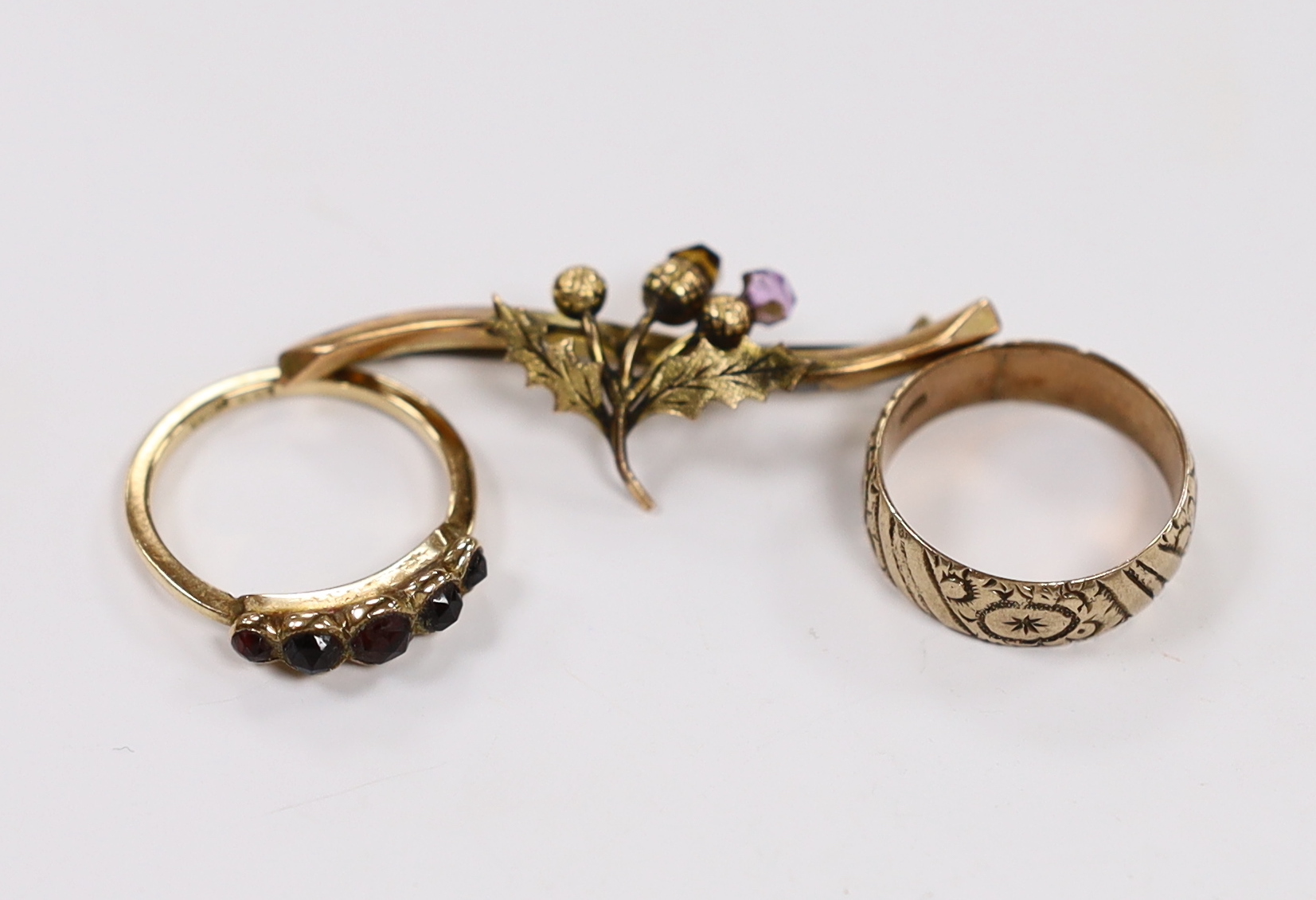 A 9ct and graduated five stone facetted garnet set ring, an engraved 9ct gold band and a 9ct gold and gem set bar brooch (stone missing), gross weight 8.5 grams.